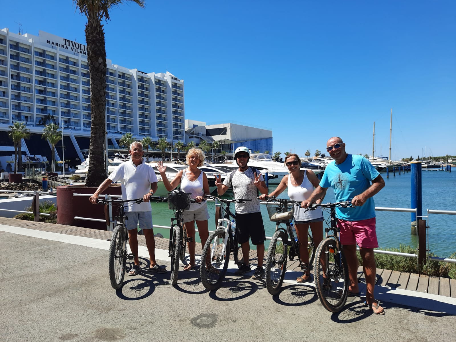 Visitors cycling along the Vilamoura marina promenade in the Algarve