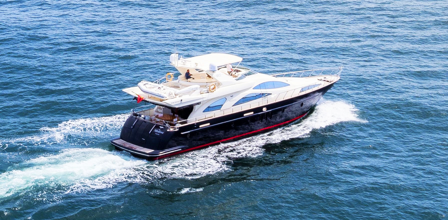 Luxury yacht sailing along the Algarve cliffs at sunset