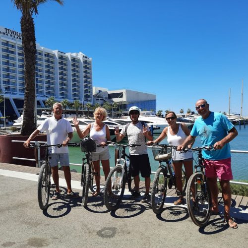 Visitors cycling along the Vilamoura marina promenade in the Algarve