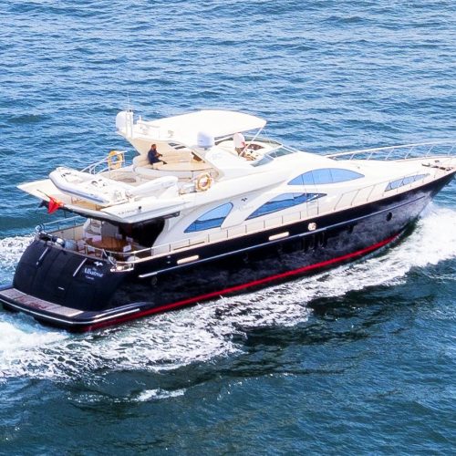 Luxury yacht sailing along the Algarve cliffs at sunset